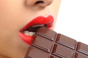 Beautiful woman red lips eating chocolate